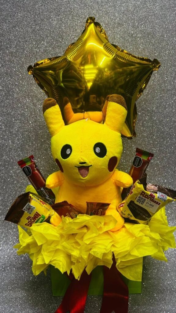 Detalle de peluche amarillo en caja con dulces