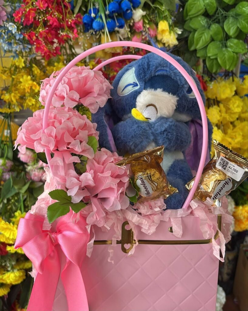 Detalle de peluche azul en caja boutique con chocolates